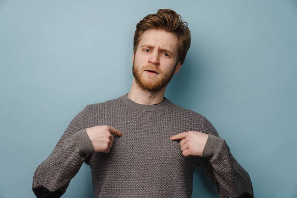 White ginger man with beard pointing fingers at himself isolated over blue background - Foto, Bild