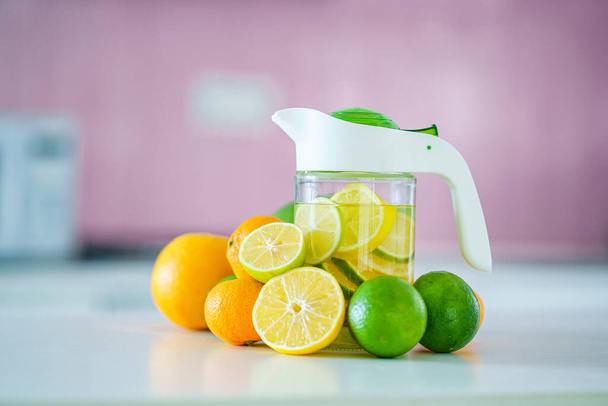 Glass jug with refreshing infused detoxification citrus water for vitamin detox drink. Slimming antioxidant drinks for diet healthy drinking  - Foto, imagen