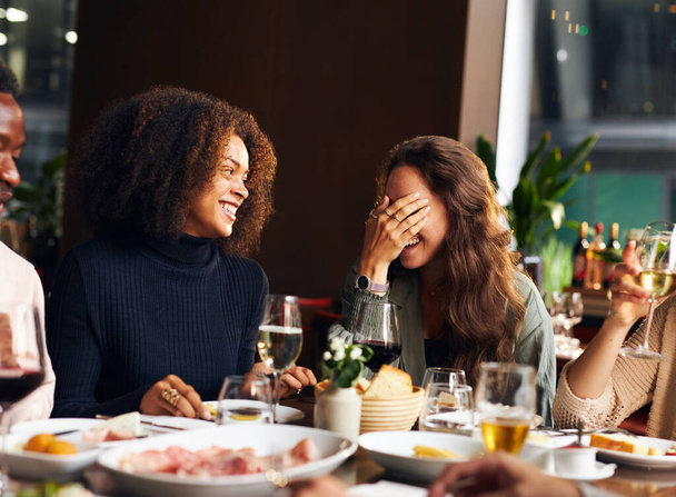 Friends telling jokes at dinner in restaurant - Foto, afbeelding