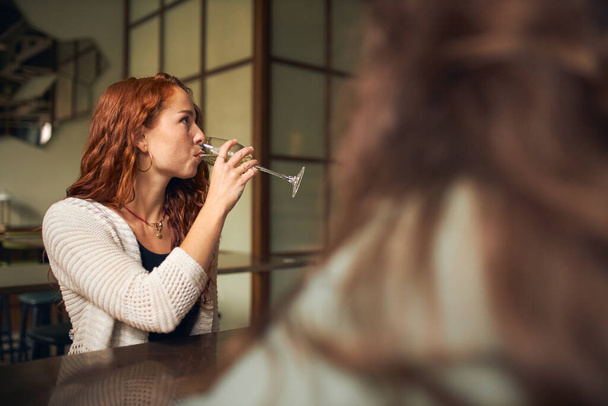 Mujer joven bebiendo vino en el bar - Foto, Imagen
