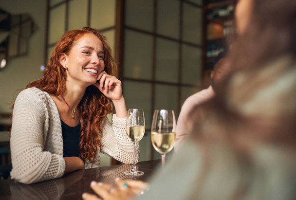 Junge Frau entspannt sich mit Freunden in Bar - Foto, Bild