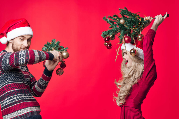 Noel süslerinin yanında bir erkek ve bir kadın duruyor. Eğlenceli bir tatil. - Fotoğraf, Görsel
