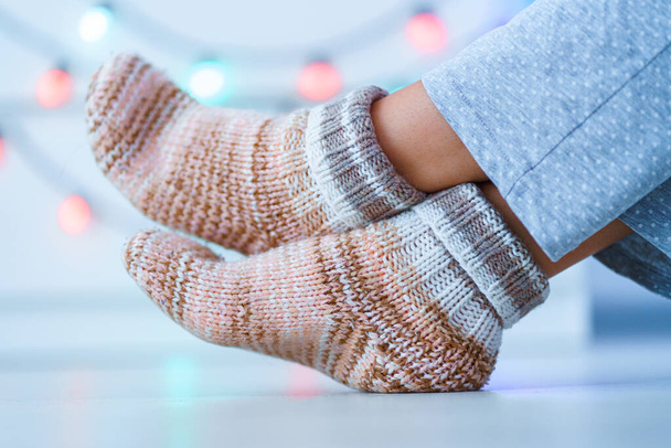 Resting female in warm knitted soft comfortable socks in wintertime at home.   - 写真・画像