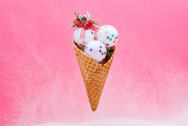 Xmas white shiny ice cream balls in waffle cone on a pink background. Winter christmas holiday concept. - Zdjęcie, obraz