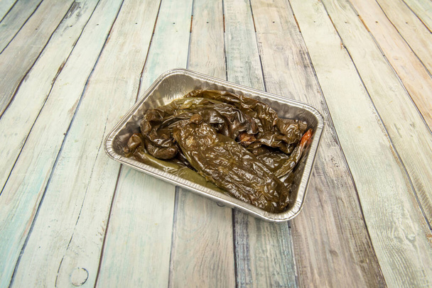 Великий смажений зелений перець типовий для недільного смаженого курячого гарніру в алюмінієвій тарі для доставки додому
 - Фото, зображення