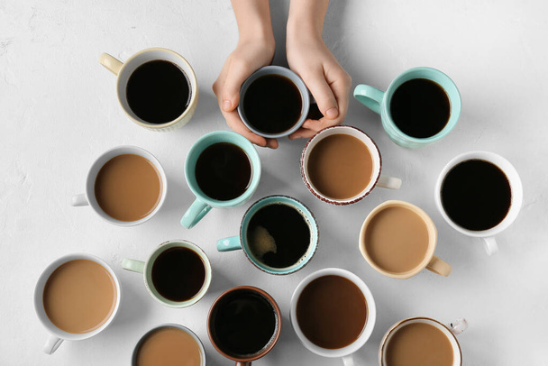 Weibliche Hände und Tassen Kaffee auf Grunge-Hintergrund - Foto, Bild