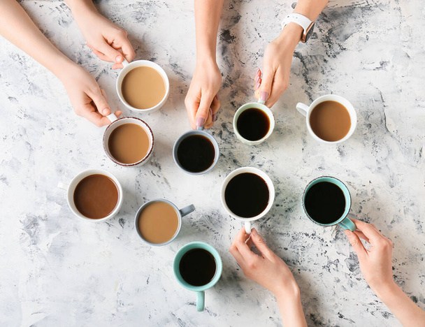 Female hands and cups of coffee on grunge background - Photo, Image