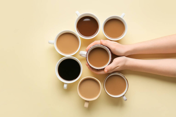 Mani femminili e tazze di caffè su sfondo di colore - Foto, immagini