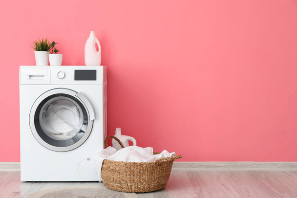 Modern washing machine with laundry near color wall - Photo, Image