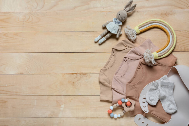 Composizione con vestiti per bambini, giocattoli e accessori su sfondo in legno - Foto, immagini