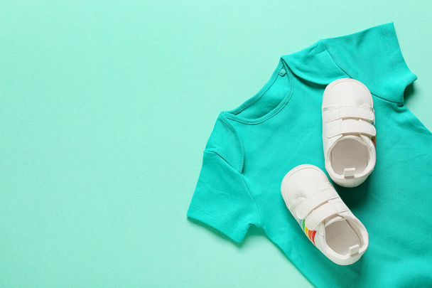 Baby clothes and shoes on color background - Foto, afbeelding