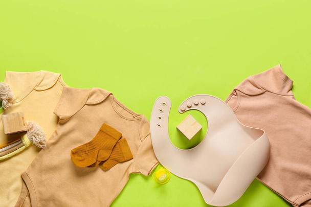 Дитячий одяг, іграшки та аксесуари на кольоровому фоні, крупним планом
 - Фото, зображення