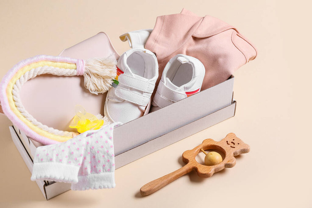 Box with baby clothes, shoes and accessories on color background - Photo, Image