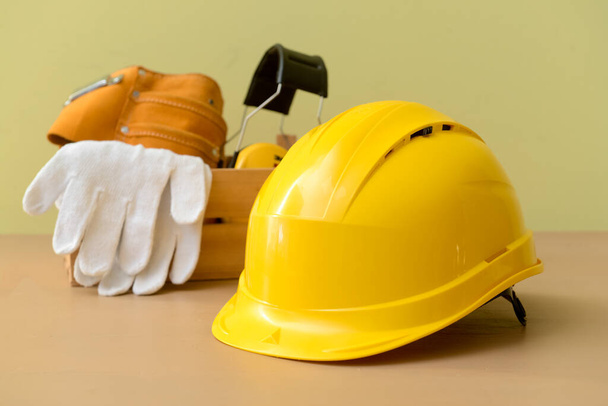 Hardhat with builder's supplies on color background - Photo, Image