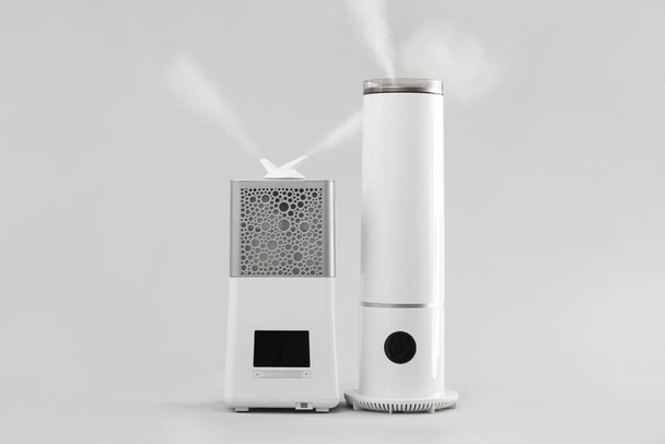 Modern humidifiers on grey background - Photo, Image