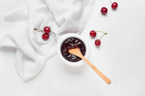 Bowl with tasty cherry jam on light background - Zdjęcie, obraz