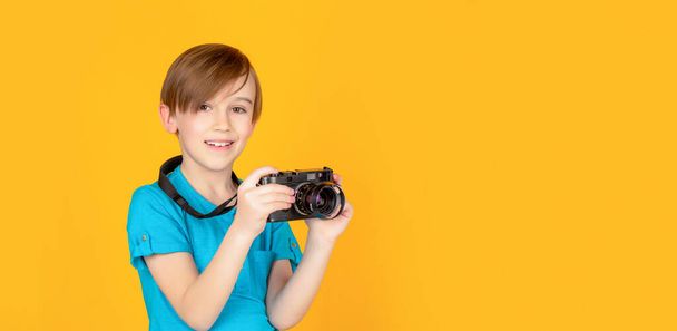 Маленький хлопчик робить фотографію, використовуючи вінтажну камеру. Дитина в студії з професійною камерою. Хлопчик використовує камери
 - Фото, зображення