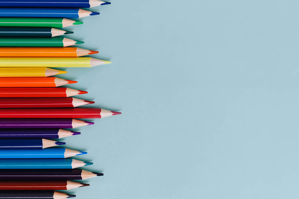 Os lápis afiados coloridos encontram-se em um fundo azul com espaço para copiar. Material escolar ou preparação escolar. - Foto, Imagem