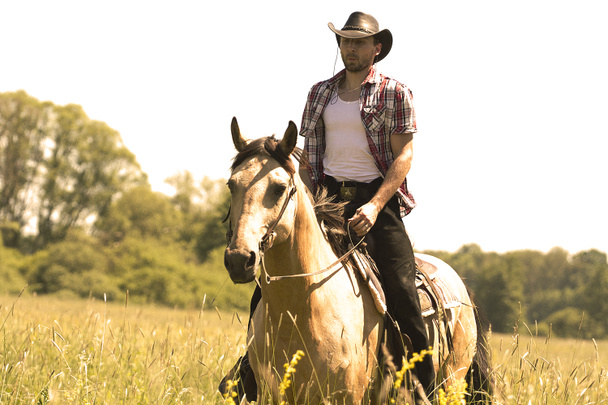 junger Cowboy-Mann reitet mit Pferd - Foto, Bild