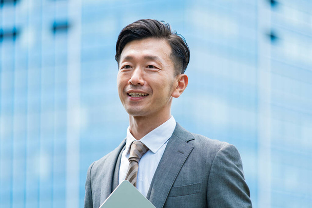 Asian businessman standing in the office district with a smile  - Foto, Imagem