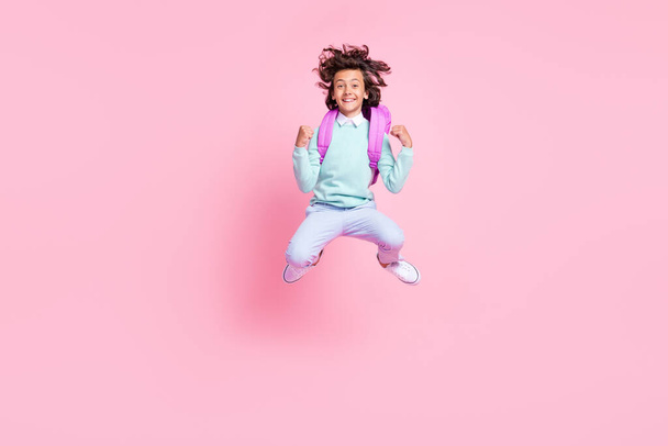 Photo of energetic sportive boy jump celebrate victory wear backpack teal shirt isolated pink color background - Foto, immagini