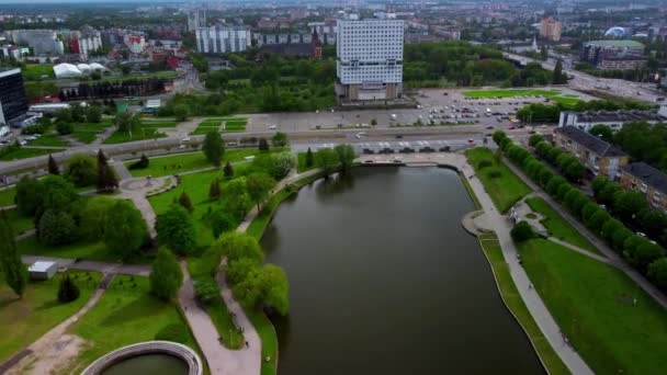 Blick auf die Stadt mit einer Straße voller fahrender Autos und einem modernen Gebäude, das vor dem Wasserkanal steht - Filmmaterial, Video