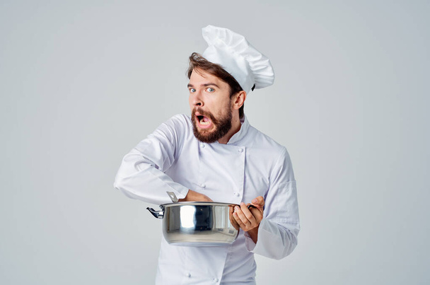 chef profesional con una cacerola en sus manos tratando de cocinar - Foto, Imagen
