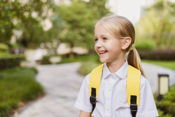 Schoolgirl back to school after summer vacations. Pupil in uniform smiling early morning outdoor.  - Φωτογραφία, εικόνα