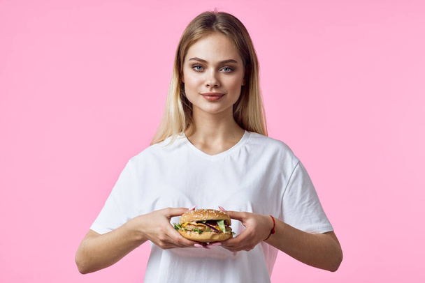 Frau im weißen T-Shirt mit Hamburger  - Foto, Bild