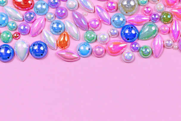 Plastic gemstones on side of pink background with copy space - Foto, Imagem