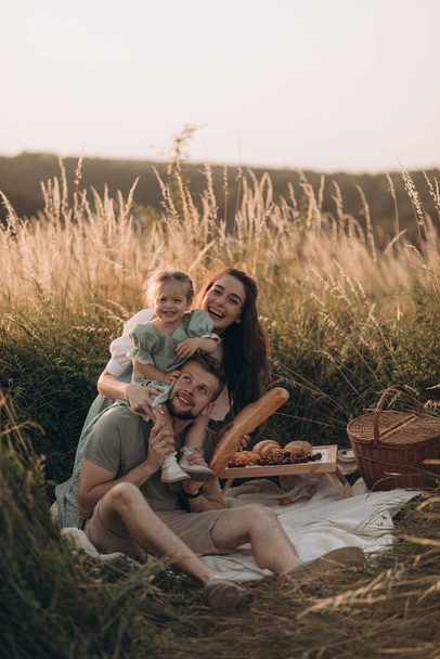 Onnellinen perhe ottaa piknik puistossa aurinkoisena kesäpäivänä - Valokuva, kuva