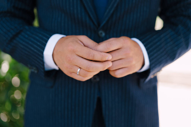 Hands of the groom in a suit with a ring on his finger - Foto, Bild