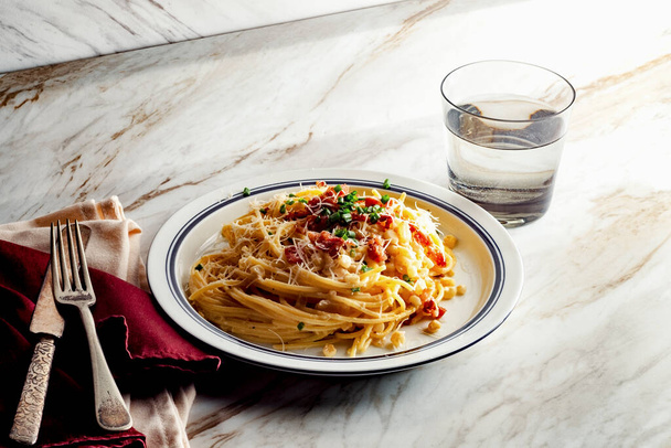Romige Italiaanse keuken spaghetti alla carbonara met romige maïspek en bieslook - Foto, afbeelding