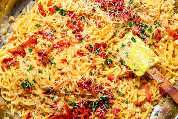 Μαγειρική κρεμώδη ιταλική κουζίνα σπαγγέτι alla carbonara με κρέμα καλαμπόκι μπέικον και σχοινόπρασο - Φωτογραφία, εικόνα