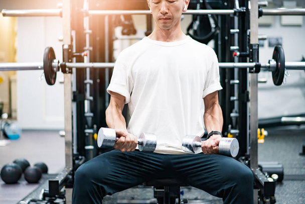 MIddle-aged man doing muscle training with dumbbells - Photo, Image