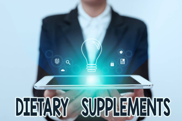 Text sign showing Dietary Supplements. Concept meaning Product taken orally intended to supplement ones diet Lady In Uniform Holding Touchpad Showing Futuristic Virtual Interface. - Photo, Image