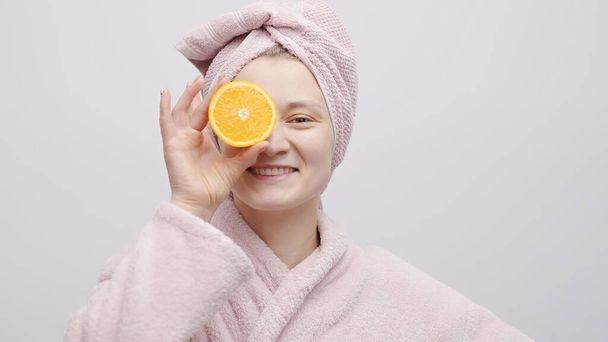 Girl Holding Half Orange And Covering Her Eye With The Orange - Hydrating Skin - Φωτογραφία, εικόνα