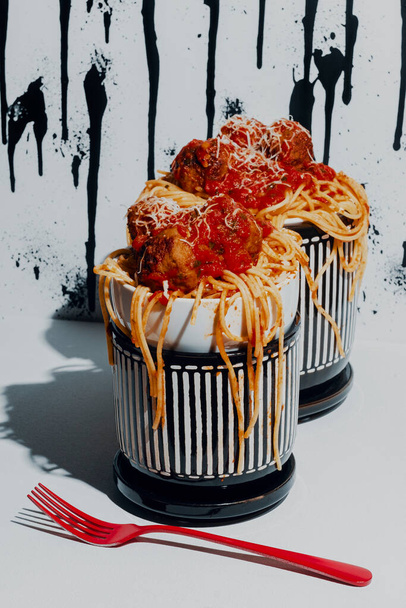 Espaguetis italianos y albóndigas en salsa marinara con patrón de fondo de goteo de pintura abstracta - Foto, Imagen