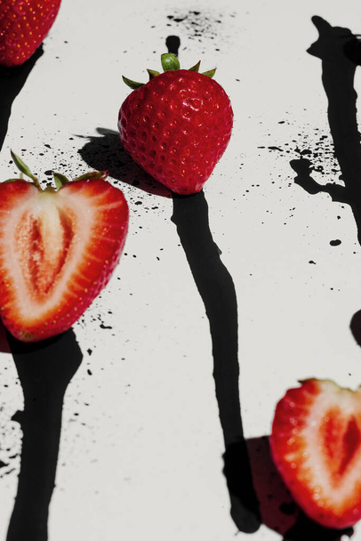 Fresh strawberries on abstract black and white paint drip background - Photo, Image