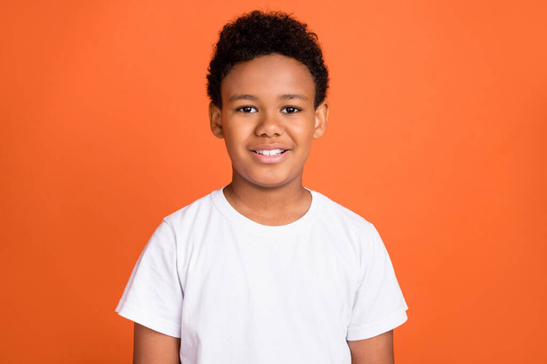 Photo of small cute boy wear white t-shirt isolated on orange color background - Foto, immagini