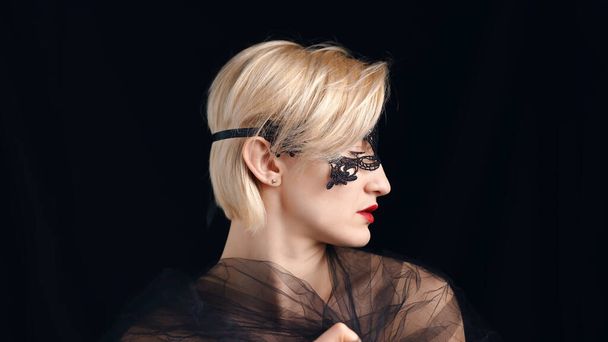 ベネチアンマスカレードマスクとレッドリップスティックを身に着けている美しいモデル-サイドビュー - 写真・画像
