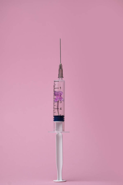 Creative vaccine concept against coronavirus on pink background, 2019-nCoV or COVID-19. Coronavirus outbreak. Respiratory syndrome epidemic virus. Syringe with flowers. Pandemic minimal background. - Photo, Image