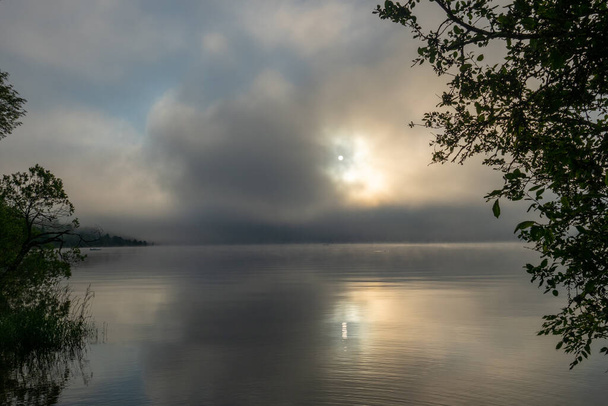 Νωρίς το πρωί στο Lac de Joux, Ελβετία: Όμορφο τοπίο με ομίχλη και τον ανατέλλοντα ήλιο - Φωτογραφία, εικόνα