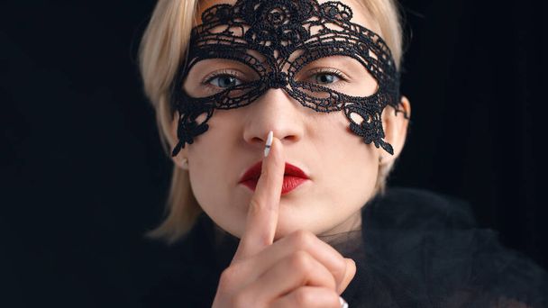 Tajemnicza dziewczyna nosząca wenecką maskę maskową - palec na ustach - Zdjęcie, obraz