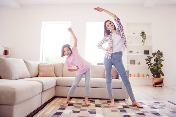 Full length photo of positive cheerful active sisters warm up training good mood inside house home apartment - 写真・画像