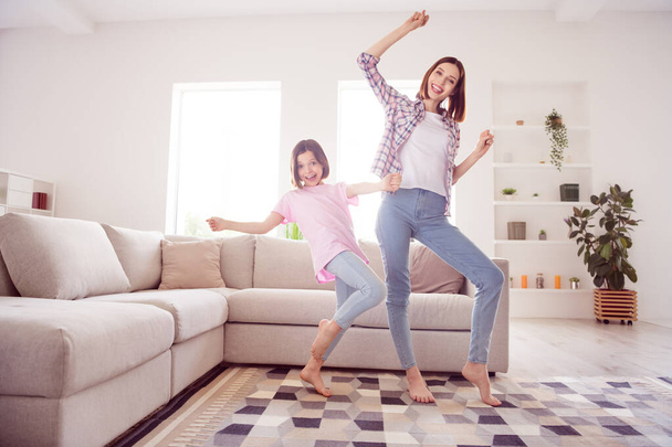 Full length photo of cheerful sisters siblings good mood winner raise fists celebrate indoors inside house home - Foto, immagini