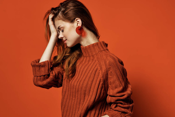Kırmızı süveter küpeli neşeli kadın çekici kozmetik model. - Fotoğraf, Görsel