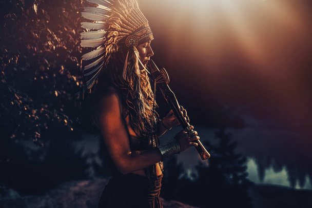 krásná šamanská dívka hraje na šamanské flétny v přírodě. - Fotografie, Obrázek