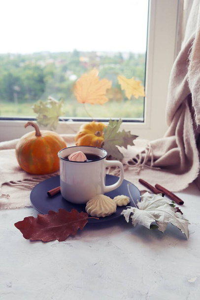 Cup of coffee, meringue, pumpkin, leaves, warm blanket, on the windowsill, the concept of home comfort, relaxation, loneliness, Thanksgiving, autumn season - Fotó, kép