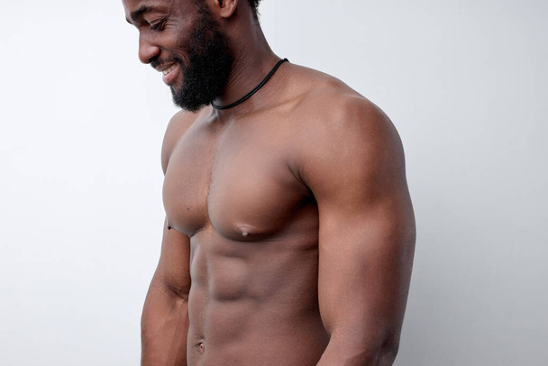 Side view of strong muscular black man with naked torso, bodybuilder concept - Фото, изображение